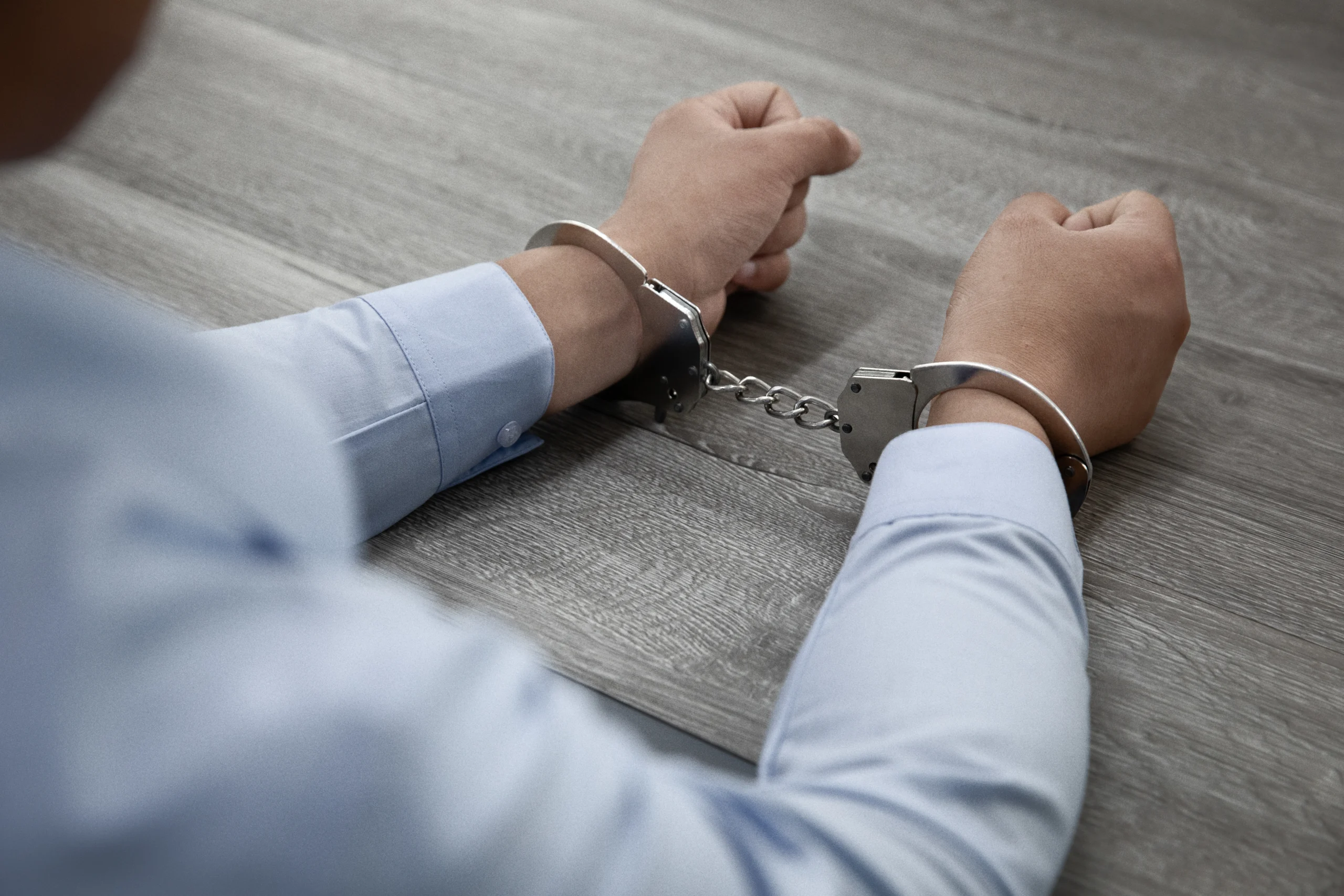 A pair of handcuffs on a wooden table
